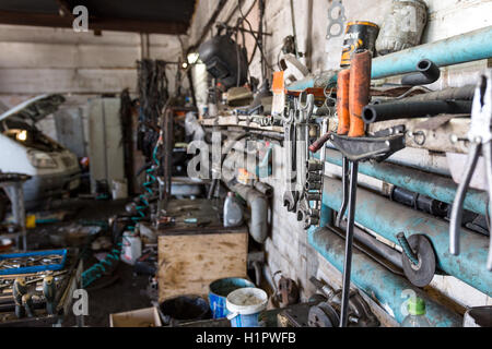 wrenches and other tools for the repair of the car hanging on the wall of the workshop Stock Photo