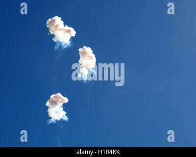 white smoke from exploding fireworks in blue sky above Valencia to celebrate Fallas festival welcoming the arrival of Spring Stock Photo