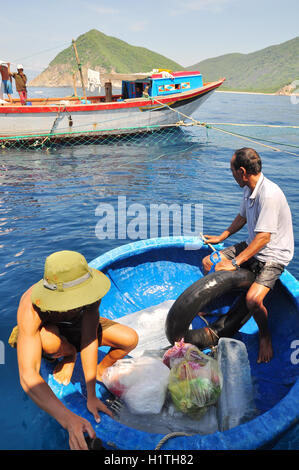 Nha Trang, Vietnam - May 4, 2012: Transferring supplements from land to fishing boats in the sea of Nha Trang bay Stock Photo