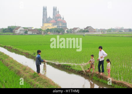 Nam Dinh, Vietnam - March 28, 2010: Children are playing in the paddy field in the countryside of the North of Vietnam Stock Photo