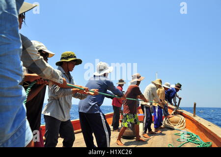 Nha Trang, Vietnam - May 5, 2012: Fishermen are catching tuna with a trawl net. Stock Photo