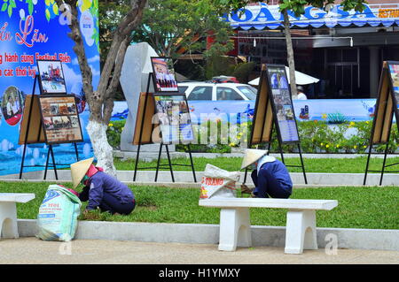 Nha Trang, Vietnam - July 11, 2015: Women are cutting grass in a park in Nha Trang city Stock Photo