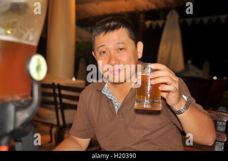 Nha Trang, Vietnam - July 11, 2015: A man is enjoying his glass of cold special beer at the Lousiana brew house in Nha Trang cit Stock Photo
