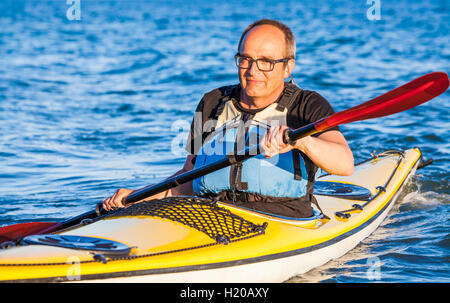 Denmark, senior man paddling, kayak Stock Photo