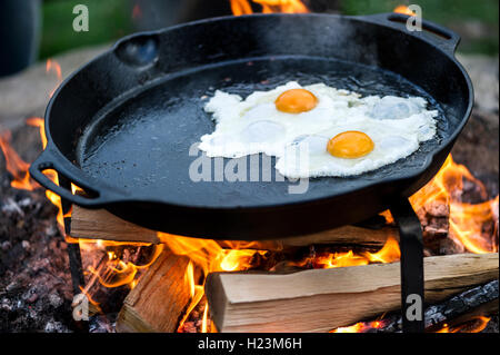 Fried eggs in a pan over an open fire Stock Photo