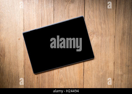 Blank tablet notebook screen isolated on wooden table. Stock Photo