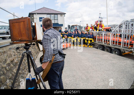 Aberystwtyth, Wales, UK. 24th Sep, 2016. Photographer JACK LOWE, grandson of ‘Dad's Army' actor Arthur Lowe, at Aberystwyth RNLI station photographing the crew and boats as part of his massive 5 year long project to document all 237 RNLI lifeboat stations in the UK, using an antique ‘plate' camera and the ‘wet collodion' process on 12”x10” glass negatives. Each negative has to be prepared by hand just before the photo is made, and he then has about 12 minutes to make the exposure and develop the image, which he does in an old ambulance he's converted into a mobile darkroom. © keith morris/Alam Stock Photo