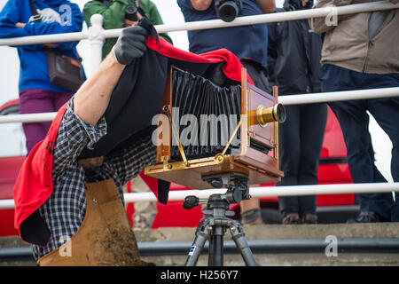 Aberystwtyth, Wales, UK. 24th Sep, 2016. Photographer JACK LOWE, grandson of ‘Dad's Army' actor Arthur Lowe, at Aberystwyth RNLI station photographing the crew and boats as part of his massive 5 year long project to document all 237 RNLI lifeboat stations in the UK, using an antique ‘plate' camera and the ‘wet collodion' process on 12”x10” glass negatives. Each negative has to be prepared by hand just before the photo is made, and he then has about 12 minutes to make the exposure and develop the image, which he does in an old ambulance he's converted into a mobile darkroom. © keith morris/Alam Stock Photo