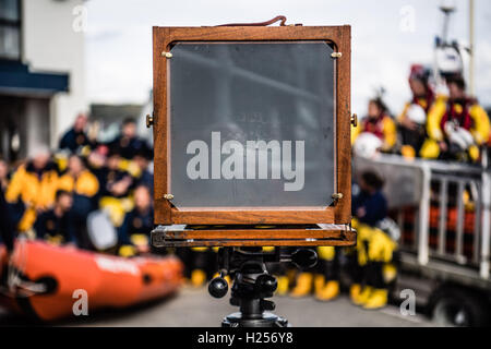 Aberystwtyth, Wales, UK. 24th Sep, 2016. Photographer JACK LOWE, grandson of ‘Dad's Army' actor Arthur Lowe, at Aberystwyth RNLI station photographing the crew and boats as part of his massive 5 year long project to document all 237 RNLI lifeboat stations in the UK, using an antique ‘plate' camera and the ‘wet collodion' process on 12”x10” glass negatives. Each negative has to be prepared by hand just before the photo is made, and he then has about 12 minutes to make the exposure and develop the image, which he does in an old ambulance he's converted into a mobile darkroom. © keith morris/Alam Stock Photo