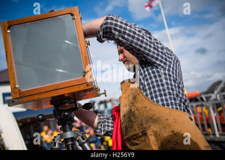 Aberystwtyth, Wales, UK. 24th Sep, 2016. Photographer JACK LOWE, grandson of ‘Dad's Army' actor Arthur Lowe, at Aberystwyth RNLI station photographing the crew and boats as part of his massive 5 year long project to document all 237 RNLI lifeboat stations in the UK, using an antique ‘plate' camera and the ‘wet collodion' process on 12”x10” glass negatives. Each negative has to be prepared by hand just before the photo is made, and he then has about 12 minutes to make the exposure and develop the image, which he does in an old ambulance he's converted into a mobile darkroom. © keith morris/Alam Stock Photo