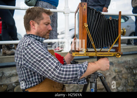 Aberystwtyth, Wales, UK. 24th Sep, 2016. Photographer JACK LOWE, grandson of ‘Dad's Army' actor Arthur Lowe, at Aberystwyth RNLI station photographing the crew and boats as part of his massive 5 year long project to document all 237 RNLI lifeboat stations in the UK, using an antique ‘plate' camera and the ‘wet collodion' process on 12”x10” glass negatives. Each negative has to be prepared by hand just before the photo is made, and he then has about 12 minutes to make the exposure and develop the image, which he does in an old ambulance he's converted into a mobile darkroom. © keith morris/Alam Stock Photo