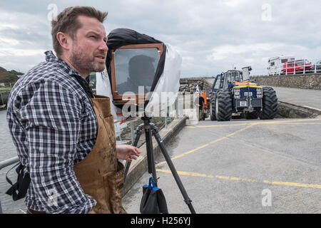 Aberystwtyth, Wales, UK. 24th Sep, 2016. Photographer JACK LOWE, grandson of ‘Dad's Army' actor Arthur Lowe, at Aberystwyth RNLI station photographing the crew and boats as part of his massive 5 year long project to document all 237 RNLI lifeboat stations in the UK, using an antique ‘plate' camera and the ‘wet collodion' process on 12”x10” glass negatives. Each negative has to be prepared by hand just before the photo is made, and he then has about 12 minutes to make the exposure and develop the image, which he does in an old ambulance he's converted into a mobile darkroom. © keith morris/Alam Stock Photo