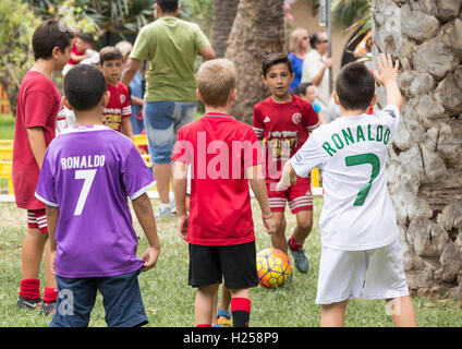 Las Palmas, Gran Canaria, Canary Islands, Spain. 24th Sep, 2016. Local Real Madrid fans play football in the hotel garden between palm trees as they wait outside the team hotel, hoping that Cristiano Ronaldo and the rest of the team will come out to sign shirts ahead of Saturday nights game against Las Palmas in the Spanish league (La Liga). For Real Madrid and their fans the game against Las Palmas involves a return flight of more than 2,000 miles. Credit:  Alan Dawson News/Alamy Live News Stock Photo
