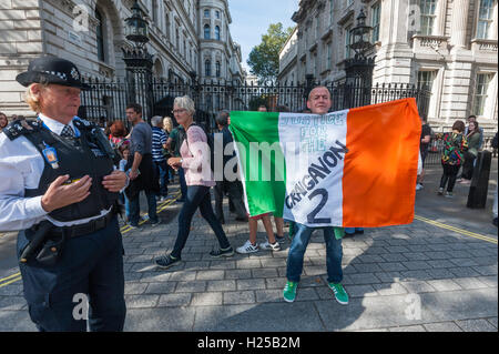 London, UK. 24th September 2016. A protester  holds an Irish flag with the message 'Justice for the Craigavon 2'  in front of the gates to Downing St during the protest by the Irish Republican Prisoners Support Group called for their release, Brendan McConville and John Paul Wooton were convicted of killing of Northern Ireland police office Stephen Carroll in March 2009. They were convicted on the evidence of a discredited witness who was allegedly paid both by members of the police force and the tabloid press despite the absence of any forensic evidence to connect them with the weapon used. T Stock Photo