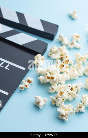 Popcorn and clapperboard on colorful background. Stock Photo