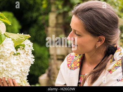 portrait of a woman holding hydrangea flower in hand Stock Photo