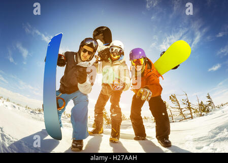 Snowboarders posing on blue sky backdrop in mountains Stock Photo