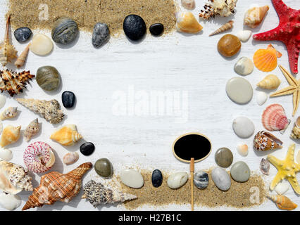 Seashells, starfish and empty plate for text on a sandy background Stock Photo