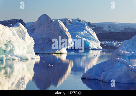 Icebergs on Sermilik Fjord near settlement of Tiniteqilaq, Greenland icefield in background, East Greenland Stock Photo