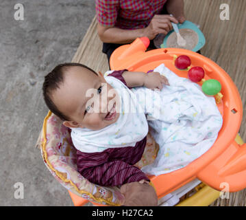 Baby eating food by mother feeding, family scene of Thailand Stock Photo