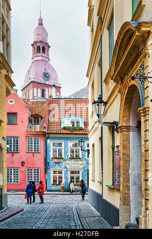 Riga, Latvia - December 26, 2015: People strolling around the streets of old Riga, Latvia. The old town is famous for its historical building such as Saint Peter church, Riga Cathedral Stock Photo
