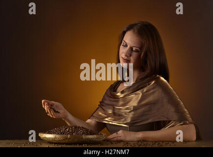 Young beautiful woman with roasted coffee beans Stock Photo