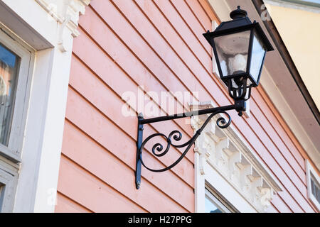 Street lamp mounted on pink wooden wall in old town of Porvoo, Finland Stock Photo