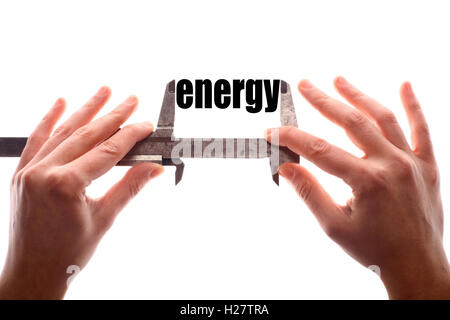 Color horizontal shot of two hands holding a caliper and measuring the word "energy". Stock Photo