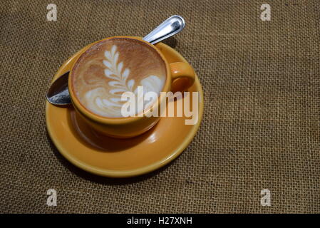 Cup of cappuccino or coffee latte with spoon and leaf decoration at Finca Filadelfia, Antigua, Guatemala Stock Photo