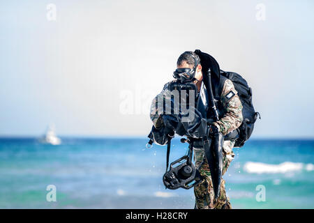 A U.S. Army Green Beret commando emerges from the Gulf of Mexico during underwater infiltration training April 2, 2015 in Okaloosa Island, Florida. Stock Photo