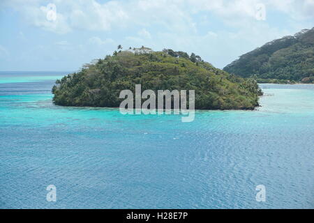 High view of a tropical island with lush vegetation, Huahine lagoon, motu Vaiorea, Bourayne bay, Pacific ocean, French Polynesia Stock Photo