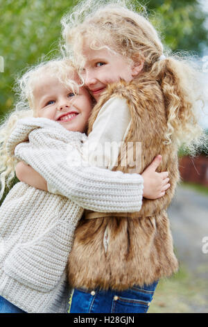 two happy kids hugging outdoors Stock Photo - Alamy
