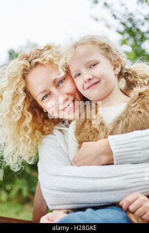 Happy mother hugging daugther with love in family portrait Stock Photo