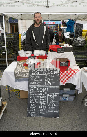 A vendor at the Union Square Green Market in New York City selling ostrich and bison meat products. Stock Photo