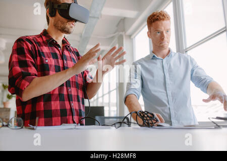 Developers testing an augmented reality device with a broad range of uses from gaming to visual aid. Young man wearing vr headse Stock Photo