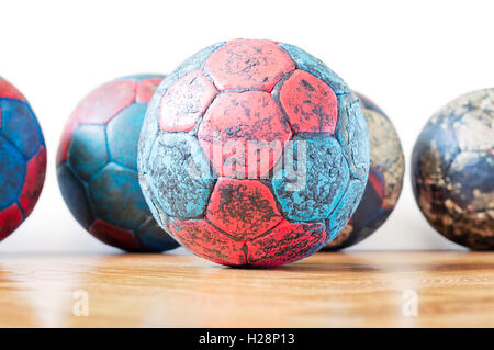 Dirty red and blue handball balls on a wooden parquet floor Stock Photo