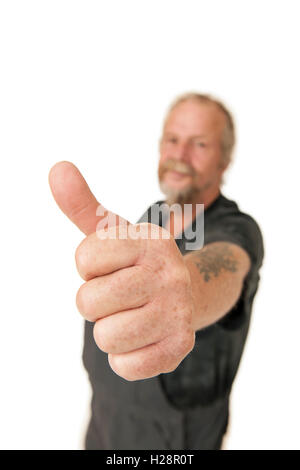 Older workers in Dungarees shows the thumb high against white background. Stock Photo