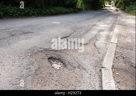 underfunding and budget cuts faced by Crowborough Council mean deep potholes are not a priority to fix on roads hazard to cycles Stock Photo