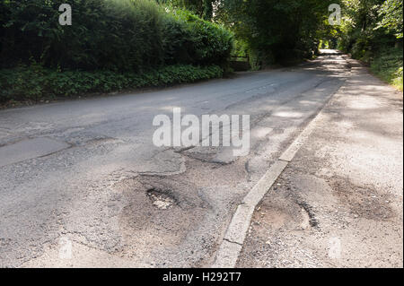 underfunding and budget cuts faced by Crowborough Council mean deep potholes are not a priority to fix on roads hazard to cycles Stock Photo