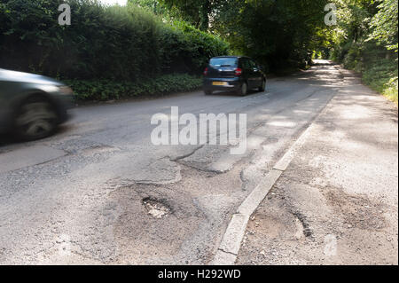 underfunding and budget cuts faced by Crowborough Council mean deep potholes are not a priority to fix on roads hazard to cycles Stock Photo