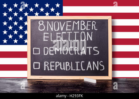 USA election concept with flag and handwriting text 8 november election democrats republicans written in chalkboard on black cra Stock Photo