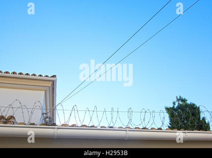 Barbed wire against blue sky, background for social issues, border, immigration, nationalism or politics. Stock Photo