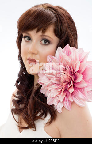 Auburn brunette english rose female portrait, wearing white jumpsuit with huge pink flower Stock Photo