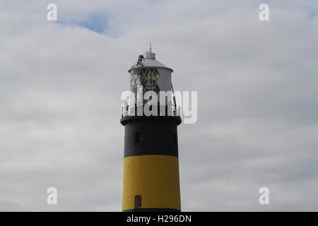 Painters on a high job painting the the lighthouse at St John's Point County Down Northern Ireland. Stock Photo
