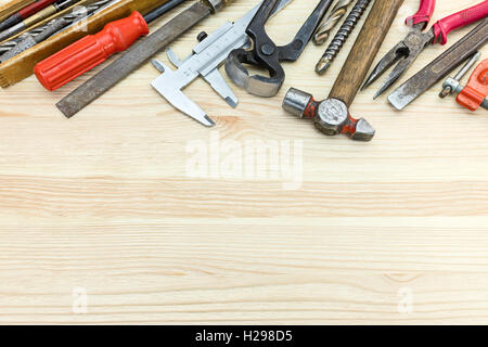 various old hand tools including hammer, caliper, screwdrivers and other on wooden table background Stock Photo