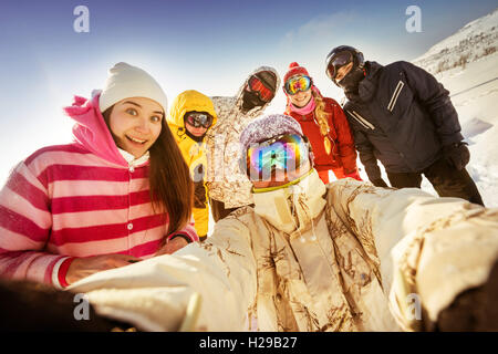 Snowboarders posing on blue sky backdrop in mountains Stock Photo