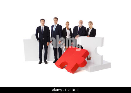 Business people team and assembled puzzle isolated on white background Stock Photo