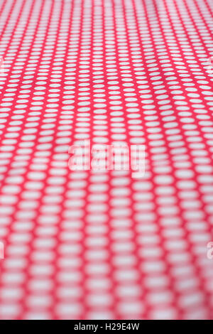 Abstract red-white polka dot cotton material - dots receding into distance. Concept 'International Dot Day', perhaps a dotty personality, dotty person Stock Photo