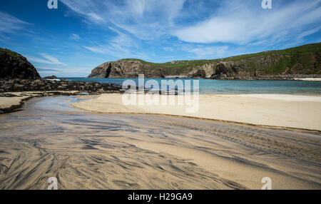 A stream of water flows across the sand and into Dalbeg Bay, Isle of Lewis, Outer Hebrides, Scotland, Stock Photo