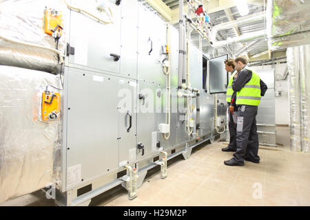Workers in electrical switchgear room of CNC plant Stock Photo